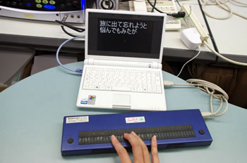 歌詞が表示されたPC画面と点字ディスプレイの写真